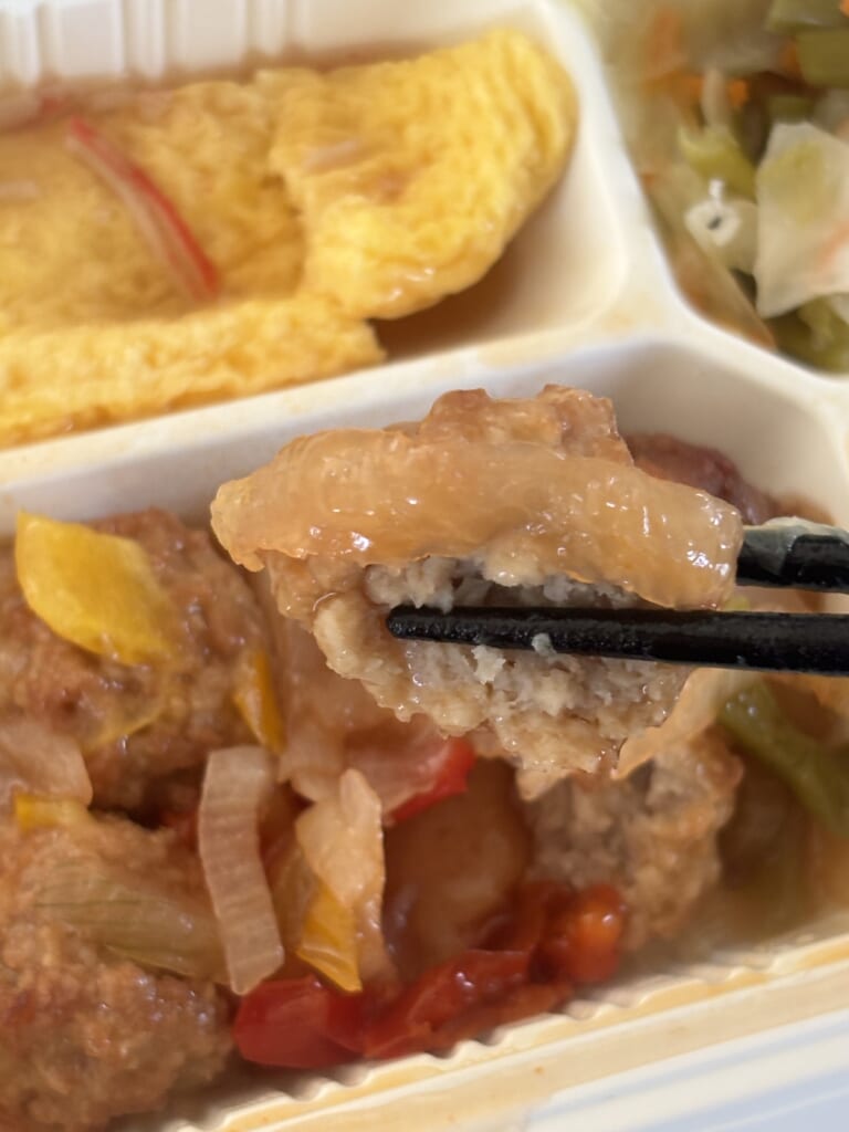 箸で持ち上げた甘酢あんかけの肉団子