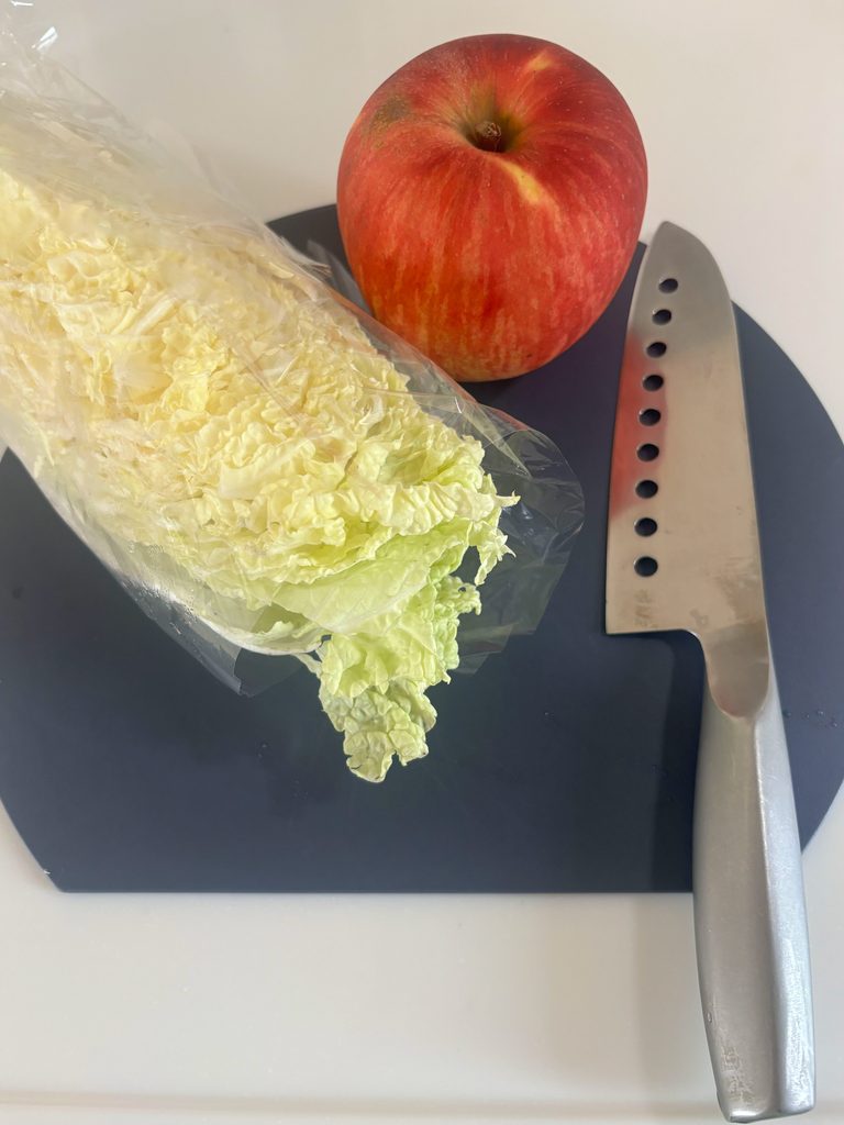 まな板にのった白菜とりんご、包丁